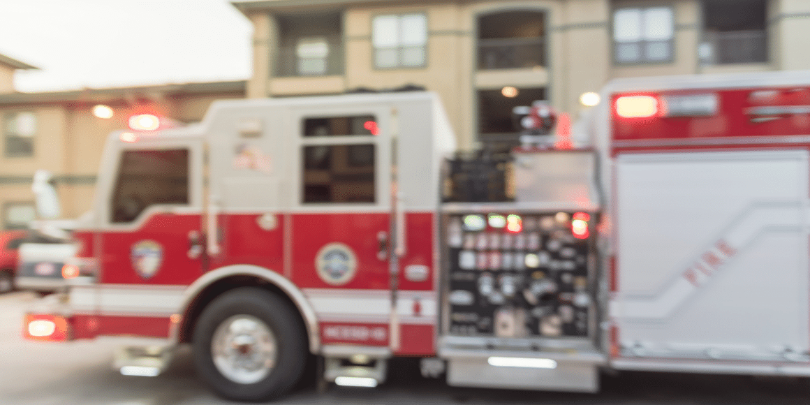 fire truck outside of an apartment building with lights on