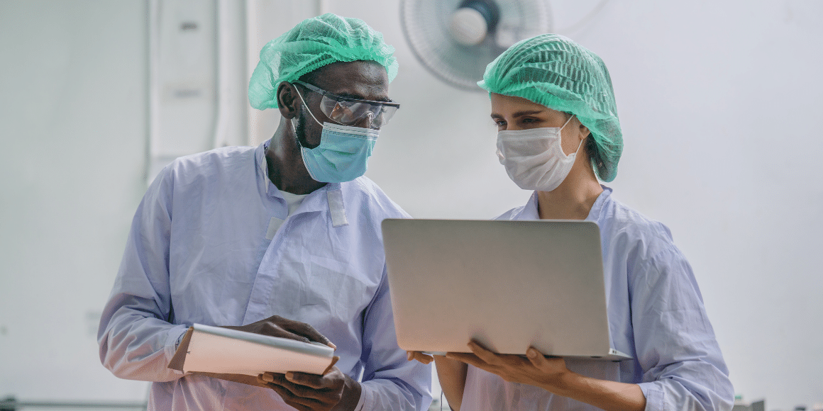 two people in a sanitation plant looking at a computer